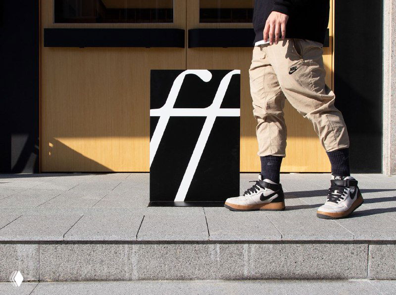 Чёрно‑белая композиция: постер с выделенной лигатурой «ff» поставлен на ступеньки — минималистичная эстетика бренда Bluff Coffee.