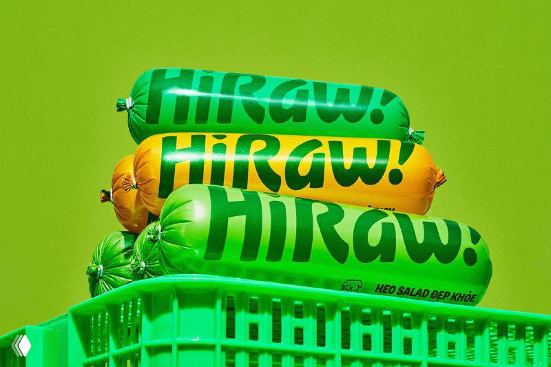 Стопка яркой упаковки корма HiRaw на зелёном фоне: жизнерадостный логотип и сочные цвета, подчёркивающие новый дружелюбный стиль бренда.