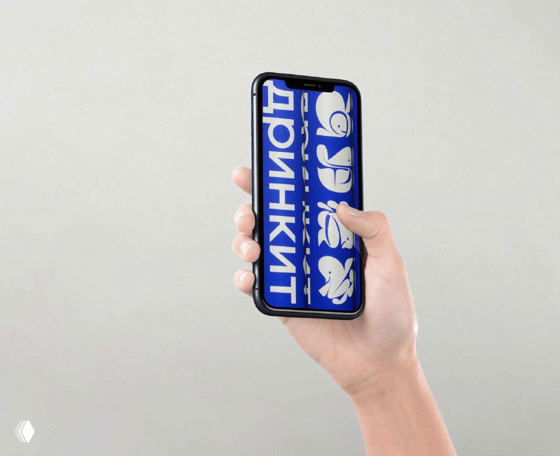 Смартфон в руке, на экране показаны карточки с логотипами‑эмоджи Drinkit: цифровое применение шрифтовой системы и мобильная презентация бренда.