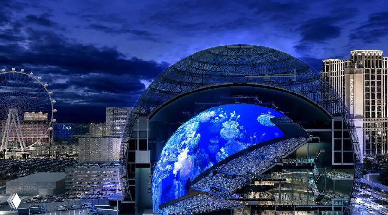Ночная панорама MSG Sphere в Лас-Вегасе: огромный сферический LED-экран с синими визуализациями на куполе, рядом видны колесо обозрения и гостиницы.