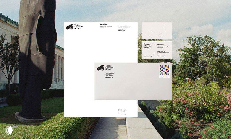 Фирменные бланки и конверты, разложенные на фоне музейного экстерьера; визуал демонстрирует применение логотипа в полиграфии и официальной документации музея.