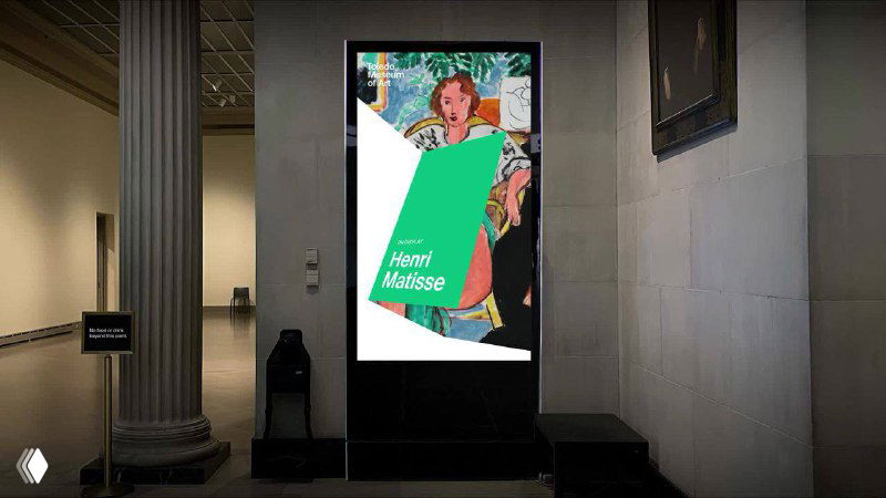 Цифровой постер в интерьере музея с плакатом и встроенным логотипом TMA — демонстрация использования графики в экспозиционных экранах и инфопанелях.