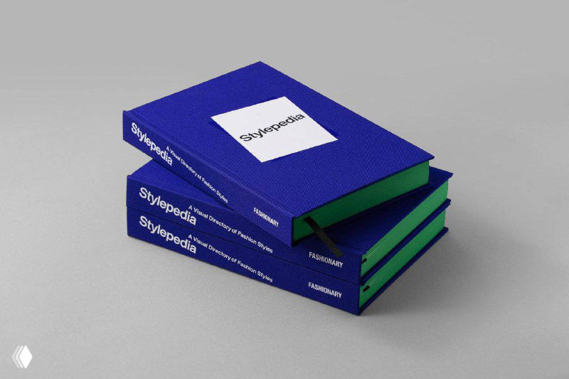 Ракурсная фотография стопки книг «Stylepedia» с синими текстильными обложками и заметными зелёными торцами, демонстрация макета издания.