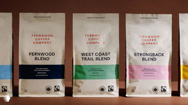 Ряд бумажных пакетов кофе Fernwood на коричневом фоне: минималистичные фронтальные этикетки, аккуратная типографика и мягкие цветные блоки.