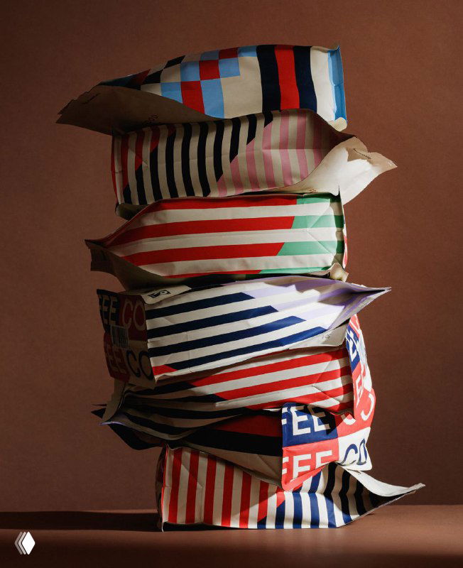 Стопка мягких пакетов с яркими полосатыми и геометрическими боковыми панелями; акцент на текстуре упаковки и взаимодействии цветов.