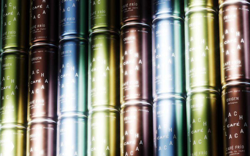 Ряд металлических банок Chachalaca в разноцветных металлических градиентах, уложенных вертикально и отражающих студийный свет