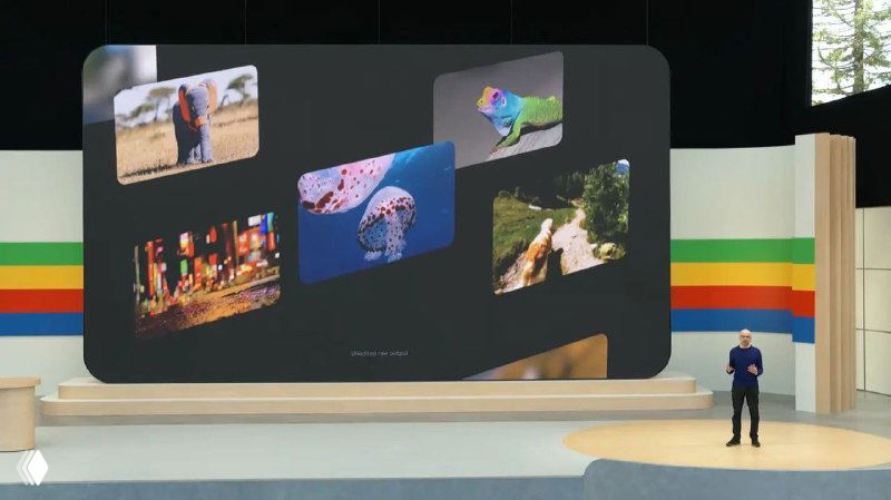 Фото сцены Google I/O 2024: большой экран с несколькими превью-картинками и выступающим докладчиком на фоне конференции.