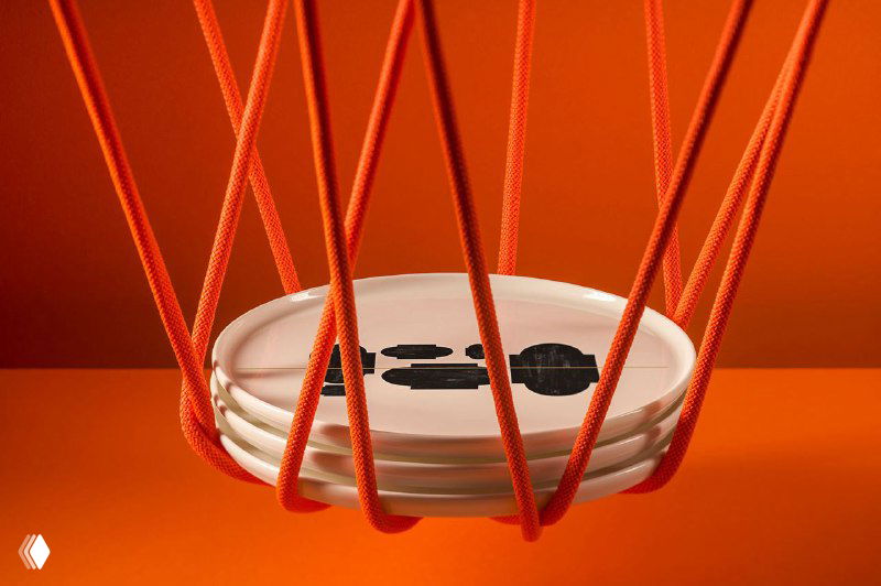 Оранжевые полиграфические материалы бренда Gaya Athens на насыщенном оранжевом фоне; видны логотип, декоративные верёвки и акцент на текстуре бумаги, показывающий качество печати.