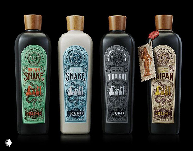 Четыре цилиндрические бутылки с разными декоративными этикетками в ретро‑стиле на тёмном фоне, демонстрация вариаций упаковочного дизайна и цветовых решений.