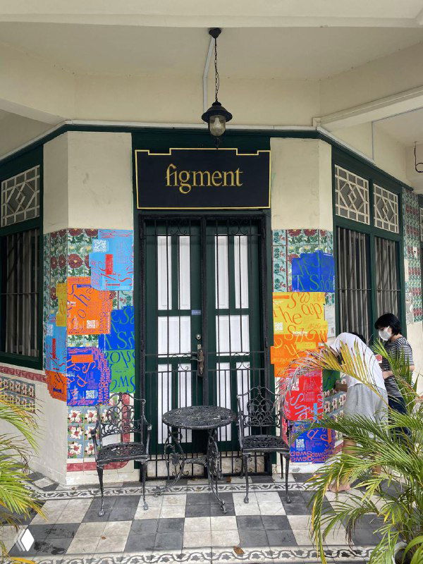 Фасад кафе или галереи, украшенный яркими постерами The Swap Show и мозаичными цветными заплатами на стене, уличный контекст проекта.