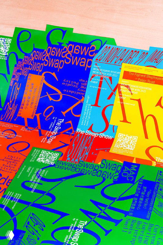 Стопка цветных постеров The Swap Show с крупной типографикой и QR-кодом на светлой поверхности, видна общая стилистика айдентики и материалы печати.