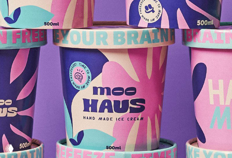 Крупный план банок Moohaus с выразительным принтом и текстовыми элементами, видно обозначение объёма и декоративные шейпы на этикетке.