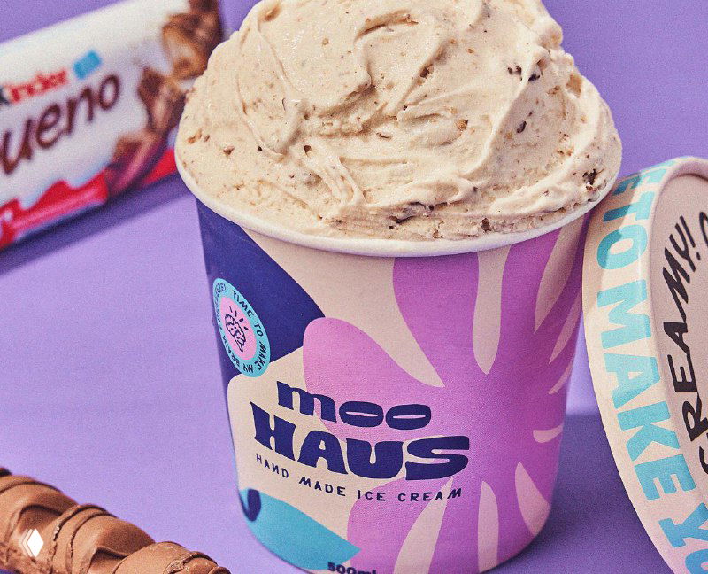 Банка мороженого Moohaus крупным планом: текстура мороженого видна сверху, этикетка в пастельных тонах с фирменной типографикой.
