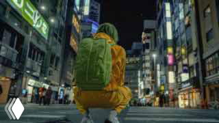 Кадр из видео AI Evolution: человек в жёлтой куртке с рюкзаком присел посреди ночной оживлённой улицы с неоновыми вывесками.