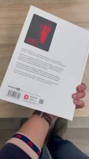 Фото сзади книги в руках: вид задней обложки, штрих-код и держание книги рукой — показывает реальный предмет и контекст использования в быту.