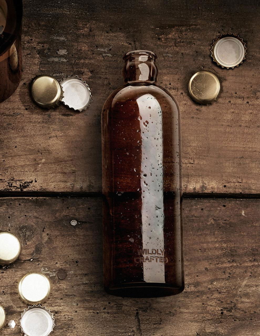 Вид сверху на коричневую стеклянную бутылку Wildly Crafted на деревянной поверхности, рядом золотистые пробки и следы влаги на стекле для атмосферности кадра