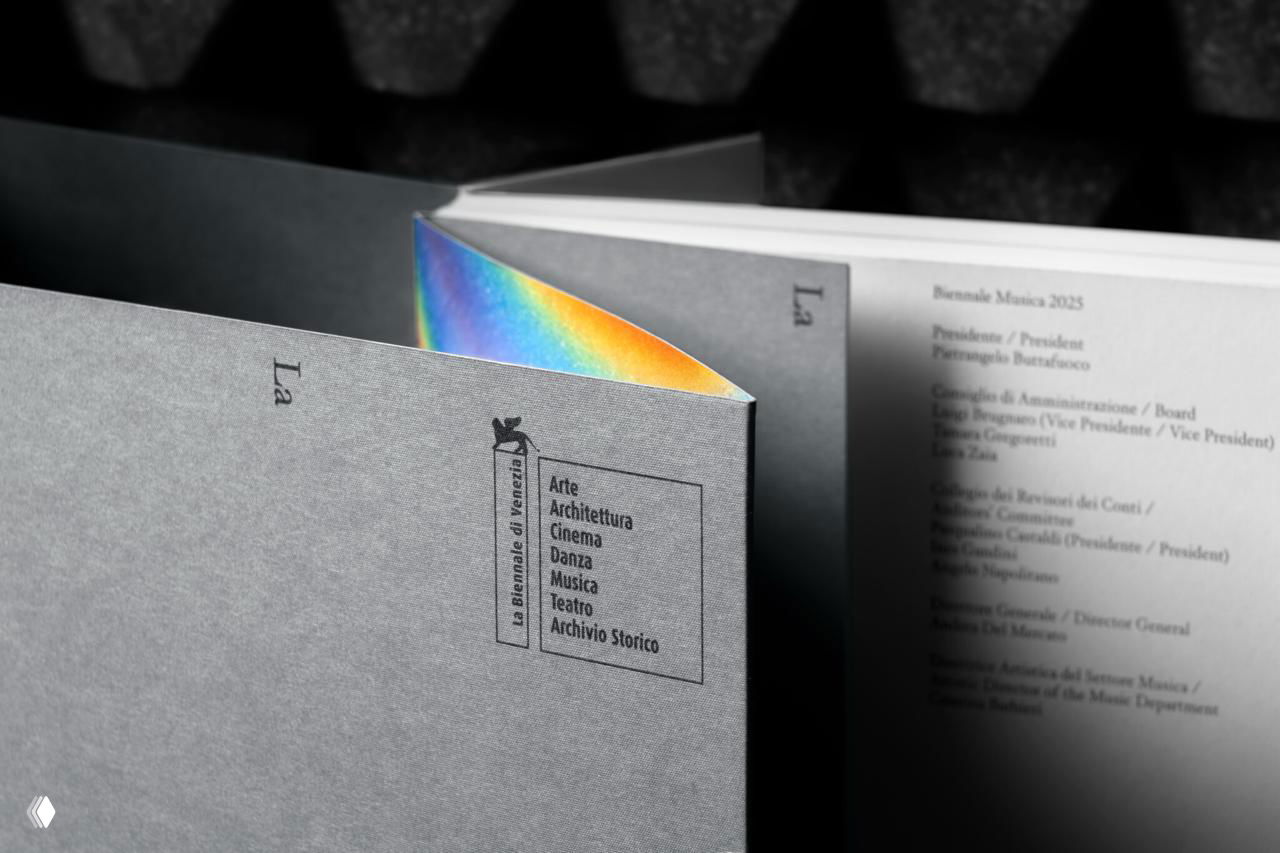 Фрагмент раскрытой обложки и внутренней страницы с текстовым содержимым, по краю виден радужный градиент как акцент дизайна.