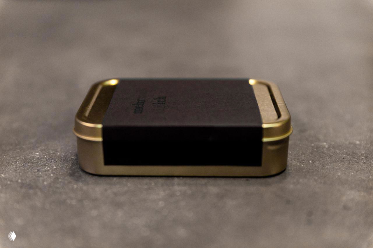 Стопка развёрнутых мини‑книг на фактурном столе; видны разноцветные корешки и экспериментальная вёрстка, подчеркнуты крупным художественным светом.