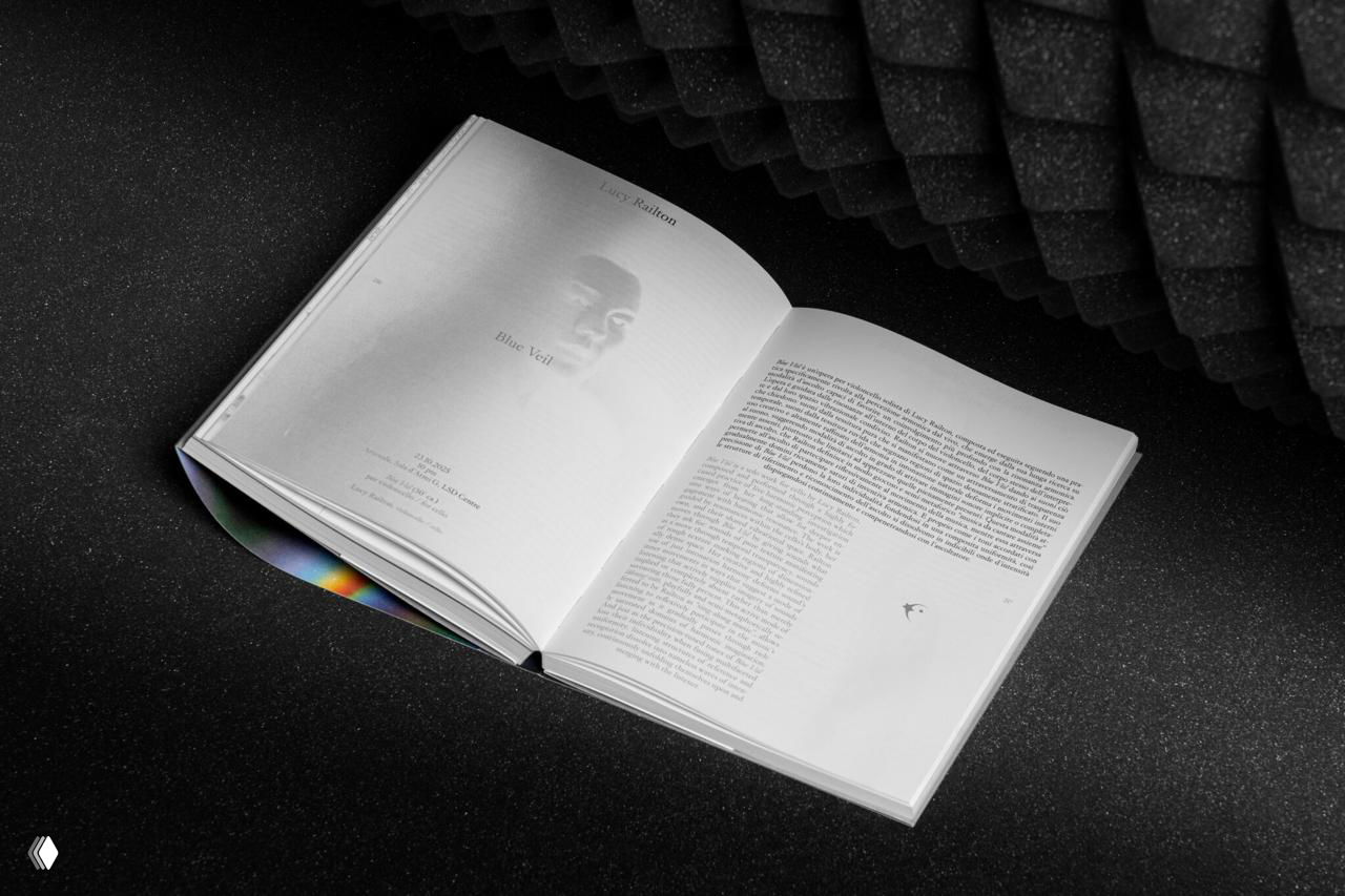 Два раскрытых разворота каталога с мелким текстом и портретными вставками, композиция подчёркнута тёмным зернистым фоном.