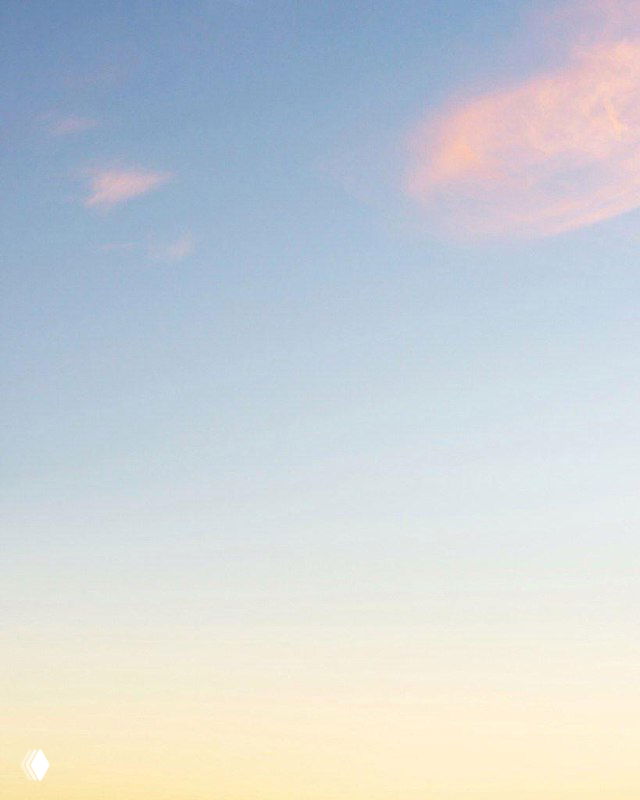 Насыщенный красно‑оранжевый градиент, переходящий в тёплые тона; кадр подчёркивает геометрию и цветовые блоки в небе.