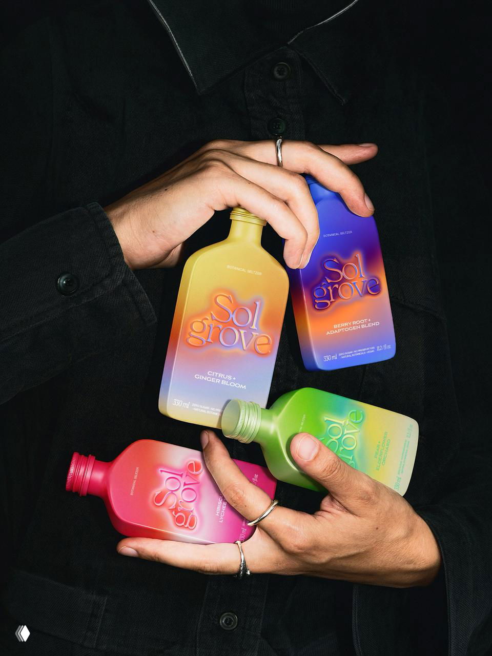 Крупный кадр рук, держащих разноцветные бутылки Sol Grove: акцент на эргономике, матовой поверхности и насыщенных переходах цвета
