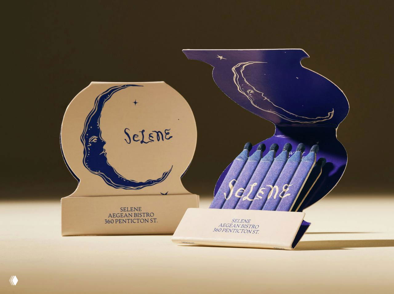 Дизайнерские коробки и спички со стилизованным полумесяцем Selene; композиция предметного набора показывает фирменную графику упаковки.