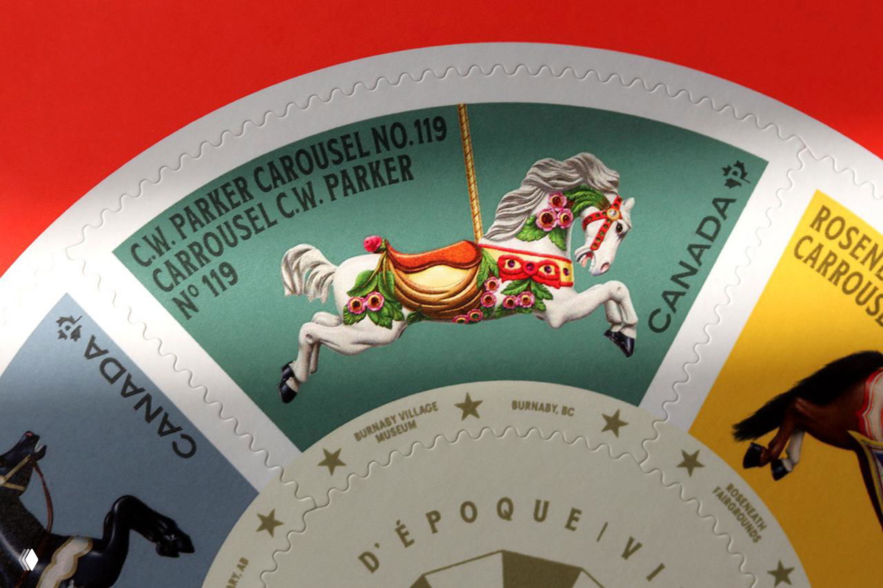 Несколько круглых листов марок, разложенных по столу; видны разные цветовые решения и повторяющиеся декоративные мотивы карусели.