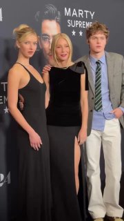 Гвинет Пэлтроу с детьми Эппл и Мозесом на красной дорожке — общий кадр с постером фильма «Марти Суприм» на заднем плане.