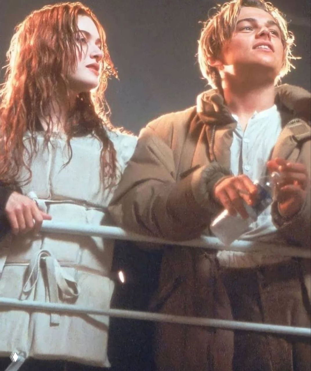 ДиКаприо и Уинслет в тёплых куртках и пледе между дублями; кадр подчёркивает контраст закулисья и гламура съёмок.