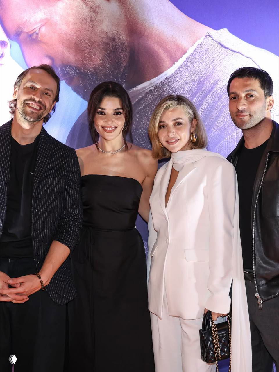 Групповой снимок: Ханде Эрчел с командой и коллегами у баннера фильма «Два мира, одно желание» во время премьерного показа