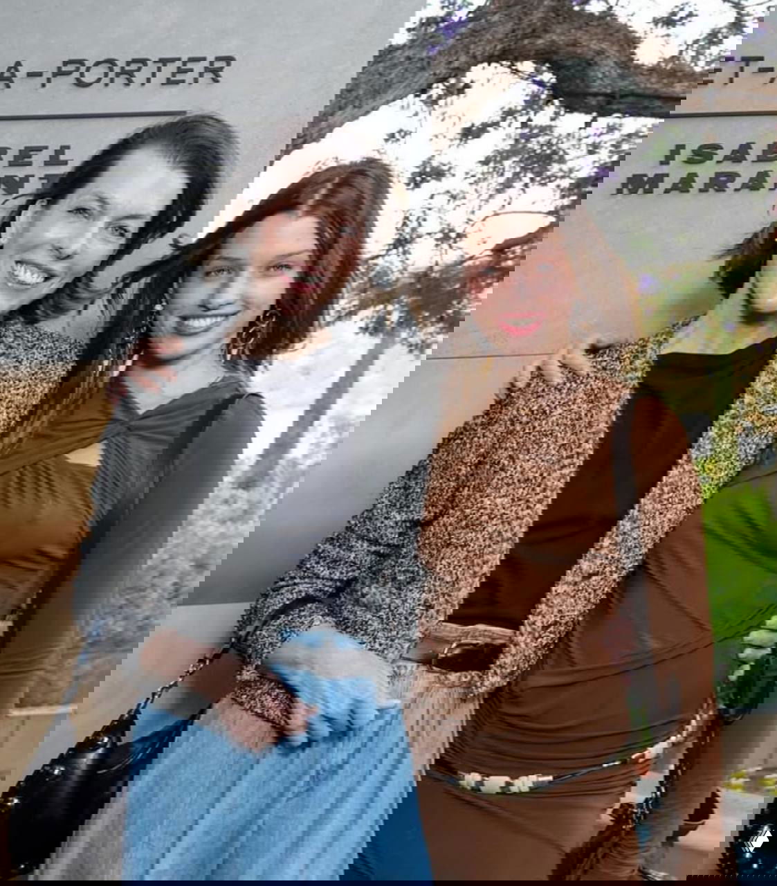 Женщина и её дочь позируют вместе на светском мероприятии у брендовой стены; стильный образ, дружеский жест и совместная поза для фотографий.