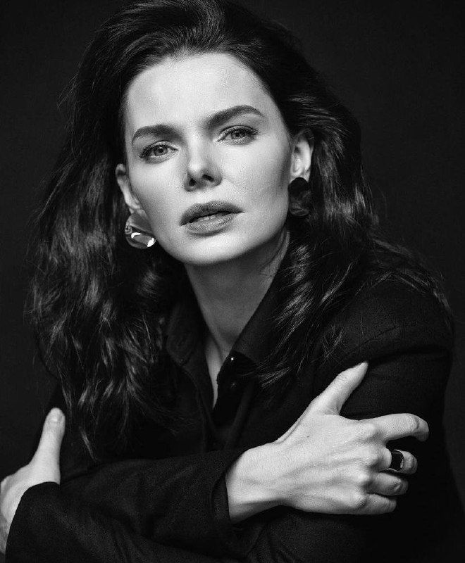 Крупный чёрно‑белый портрет женщины с тёмными волосами: выразительные черты лица, серьёзный взгляд и контрастная студийная съёмка.
