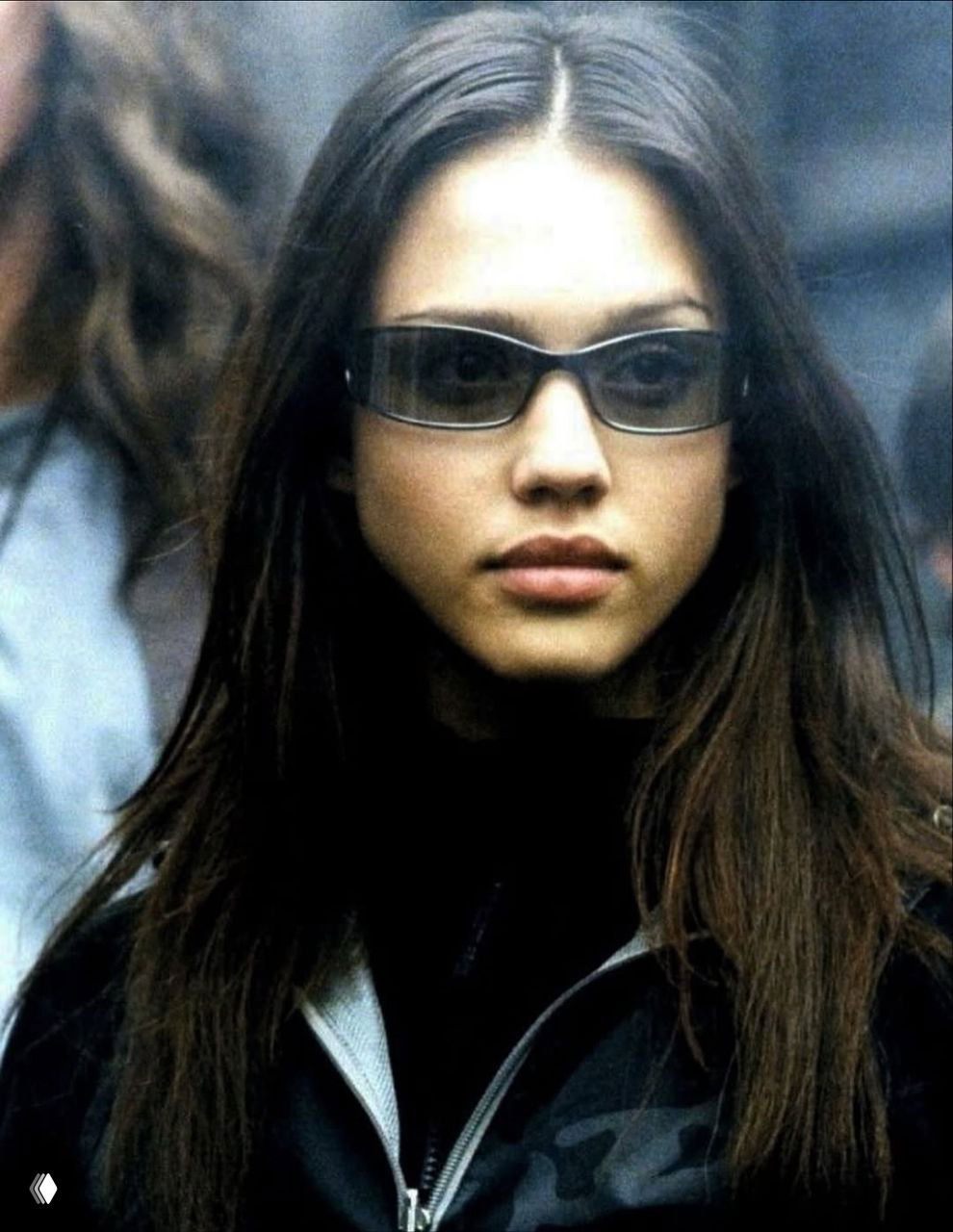 Портрет Джессики Альбы в образе героини сериала 2000-х: темные очки, прямые волосы и сосредоточенная мимика на архивном кадре.