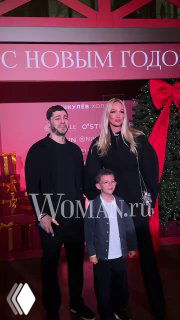 Виктория Лопырёва с мужем и сыном Марком‑Лионелем позируют на красной фотозоне «Ёлка Шкулев Холдинга», виден водяной знак Woman.ru