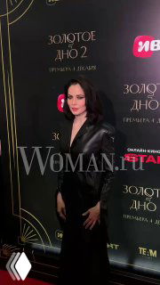 Юлия Снигирь в тёмном платье на премьере второго сезона «Золотое дно» на фоне баннера с логотипами и названием сериала; фотозона мероприятия.