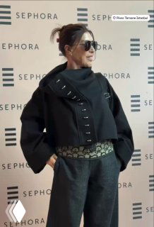 Небахат Чехре в тёмном пальто и солнцезащитных очках на светском мероприятии у брендового стенда Sephora в Стамбуле, стильный образ в полный рост.