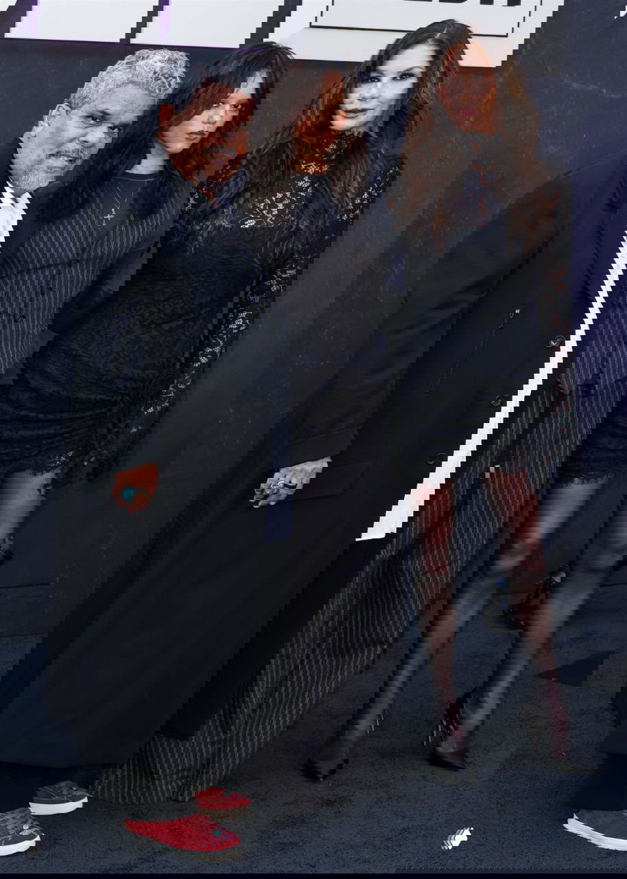 Групповое фото: Дженна Ортега, Луис Гусман и Кэтрин Зета‑Джонс вместе на фотозоне, актёры позируют в тёмных образах у декораций.