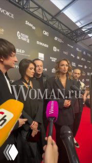 На фото: Ая, солистка «Город 312», вместе с коллегами на красной дорожке перед шоу — в кадре микрофоны и пресс‑волл с логотипами.