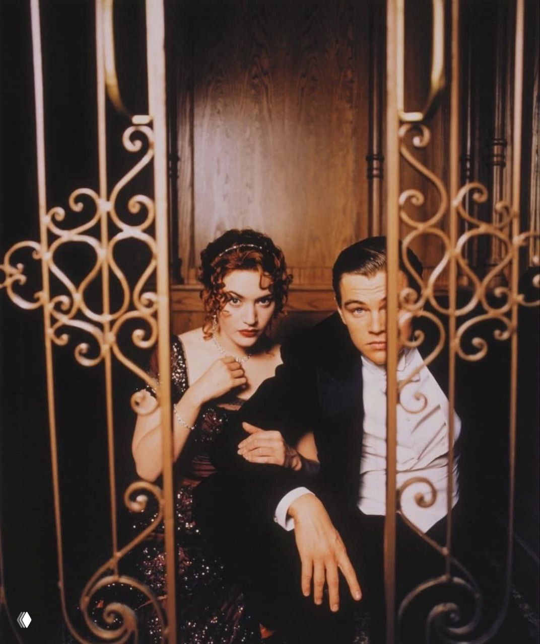 Архивный кадр: Леонардо ДиКаприо и Кейт Уинслет в костюмах эпохи за декоративной решёткой на съёмочной площадке фильма «Титаник».