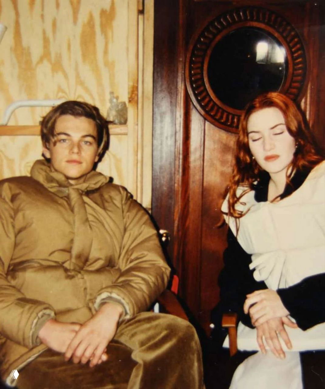 Леонардо ДиКаприо и Кейт Уинслет отдыхают между дублями в тёплой одежде и гриме, закулисный снимок из архивов картины.