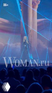 Сцена фестиваля с лазерными эффектами и проекцией певицы, кадр из номера на «Песня года 2025», вид с публики