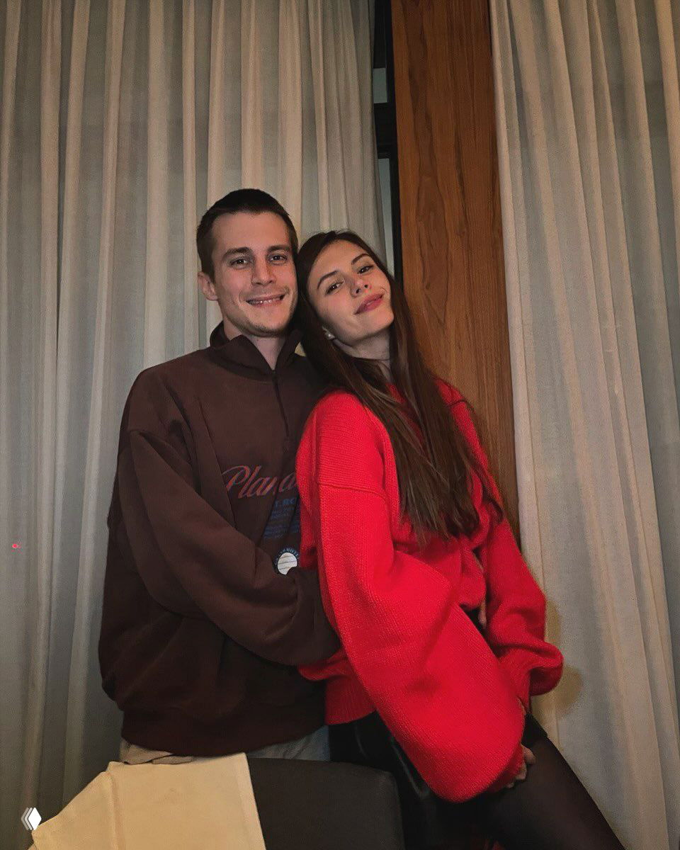 Иван Янковский и девушка на домашней фотографии: пара стоит рядом перед шторами, тёплая бытовая атмосфера и улыбки.