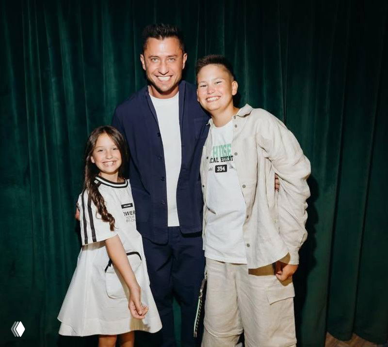 Испорченное цифровыми артефактами групповое фото: несколько людей на тёмном фоне, лица и контуры частично искажены помехами.