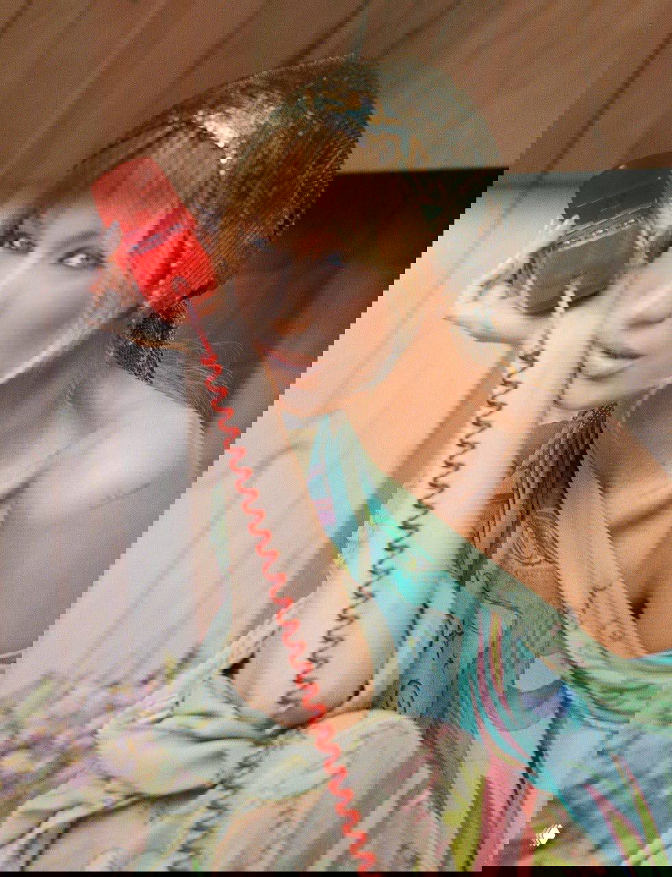 Портрет Беллы Хадид из съёмки для Dazed: ближний план с красной ретро-телефонной трубкой и лёгким бохо-макияжем.