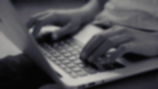 Размытое чёрно‑белое фото рук, печатающих на ноутбуке — нейтральная иллюстрация для поста об IT‑юристах и юридических онлайн‑услугах.