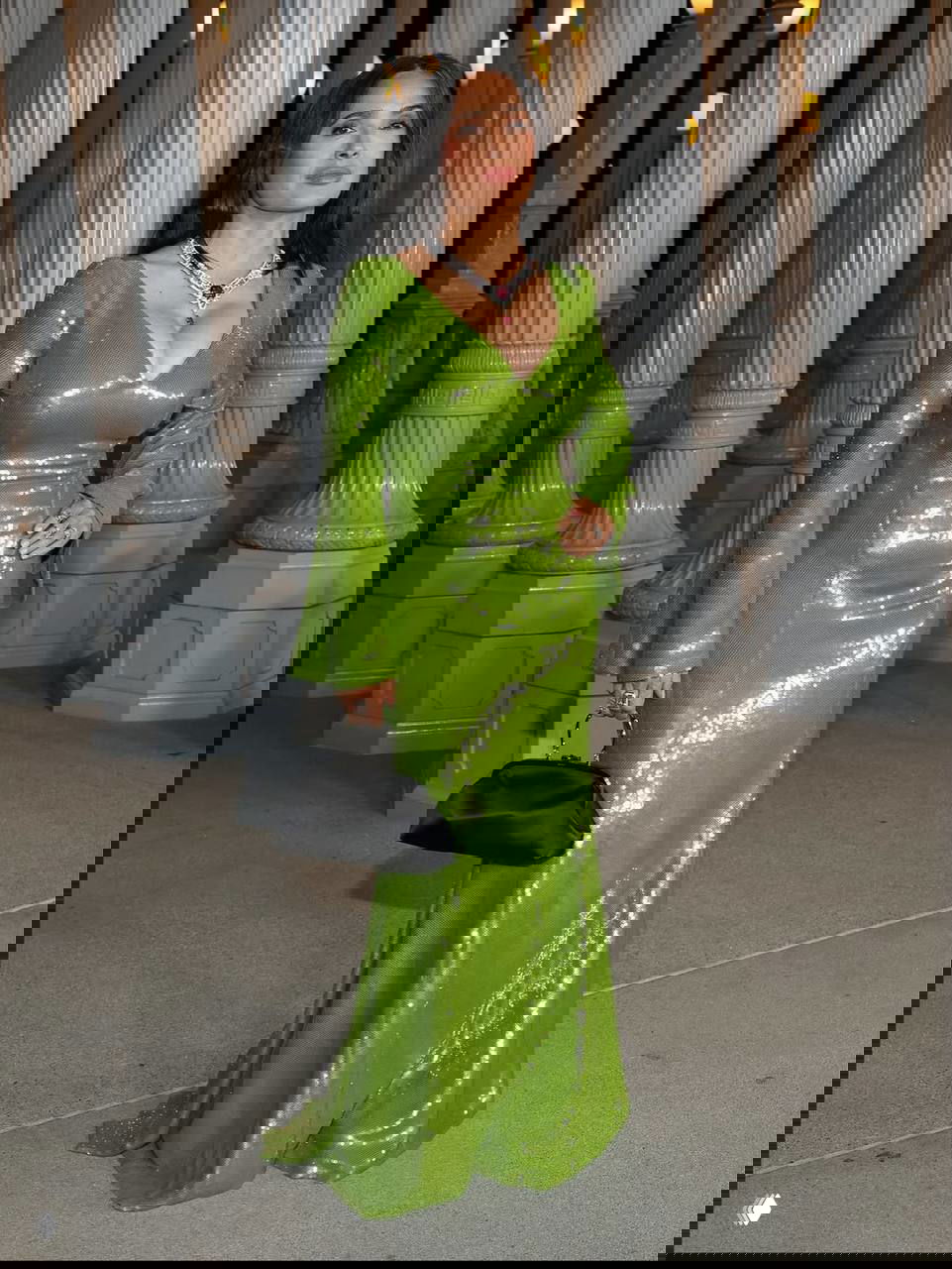 Сальма Хайек в зелёном платье, полный рост, держит чёрную мини‑сумочку; образ снят в интерьере LACMA при вечернем освещении.