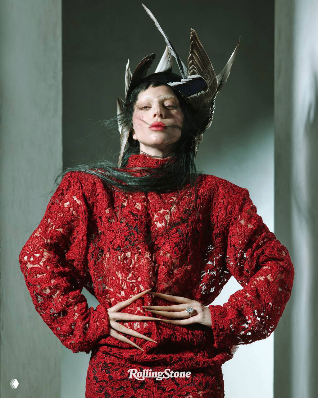 Леди Гага в красном кружевном платье и перьях на голове: статная поза и художественный свет, запечатлённые для кавер-стори Rolling Stone, высокомодный образ студийной съёмки.