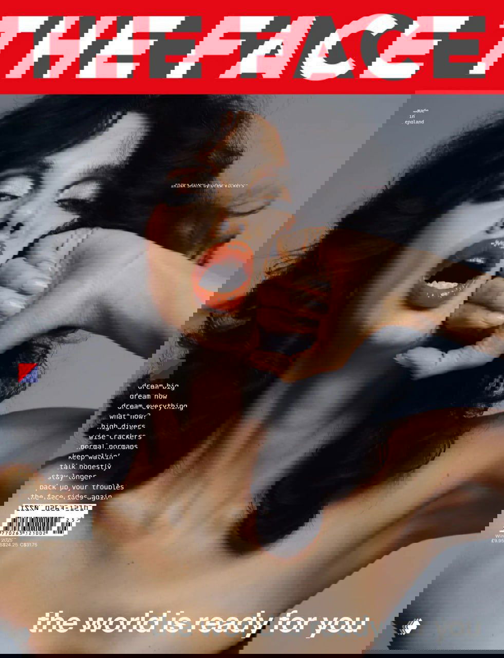 Крупный портрет Ирины Шейк для обложки The Face: глянцевый макияж, открытый рот и драматичная поза на студийном фоне, художественный свет.