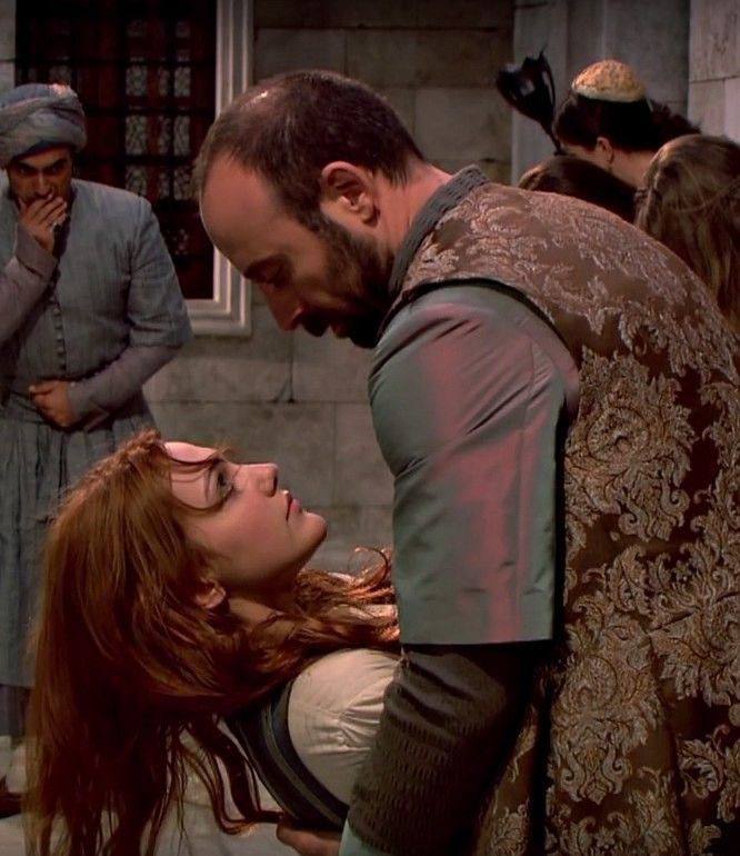 Напряжённая сцена дворца: мужчина наклоняется над женщиной, лежащей на полу — драматичный момент между персонажами в сюжете сериала.