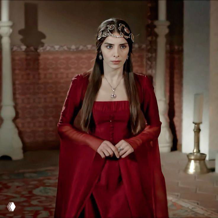 Женская героиня в короне и красном платье стоит в тронном зале: строгая поза, фактура тканей и исторический интерьер на фоне.